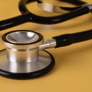 Detailed image of a stethoscope on a vibrant yellow surface.
