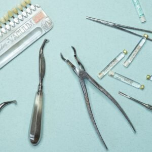 Overhead shot of various dental tools and materials arranged on a blue background.
